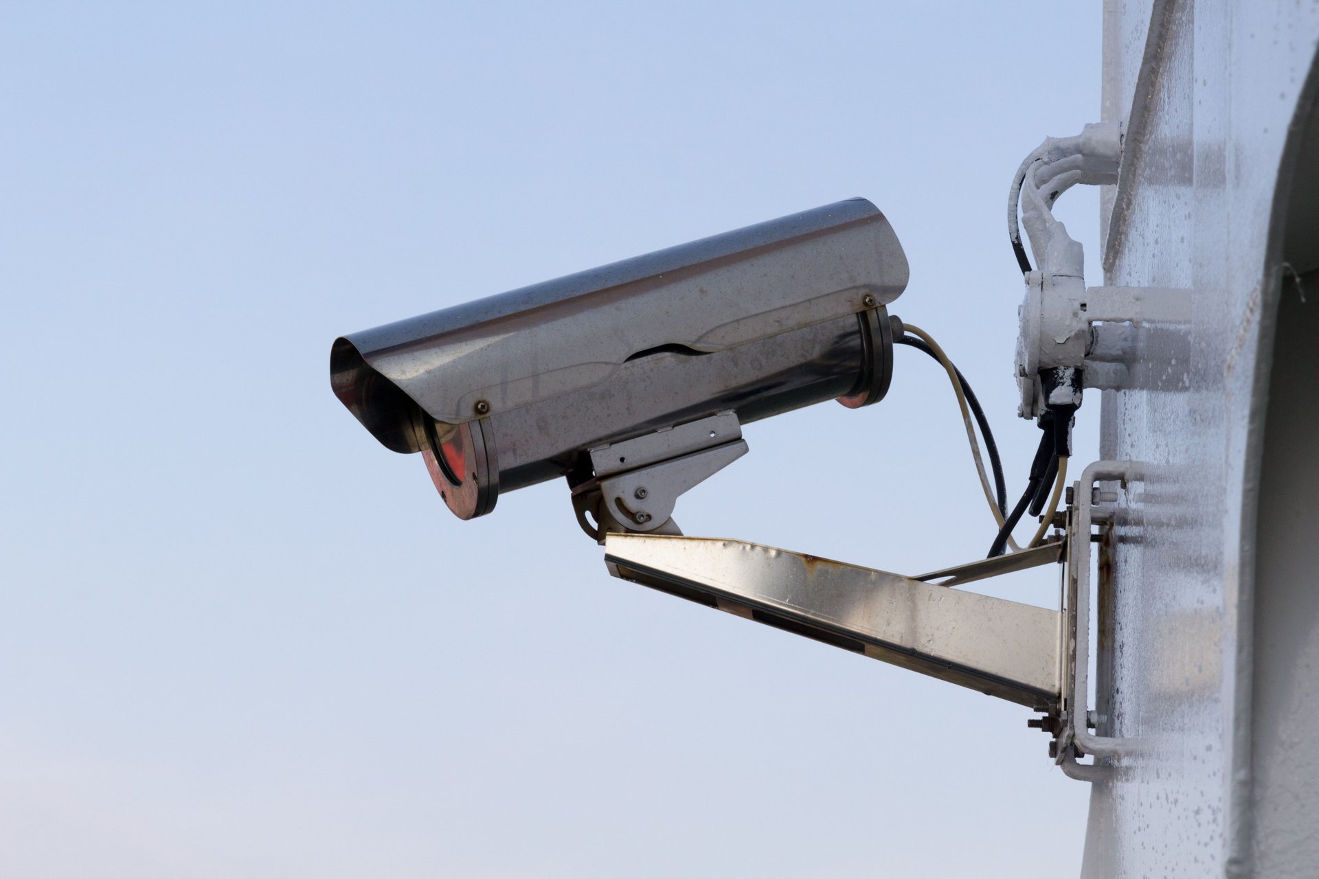 Cámara de seguridad CCTV tipo bullet montada en pared exterior sobre soporte metálico