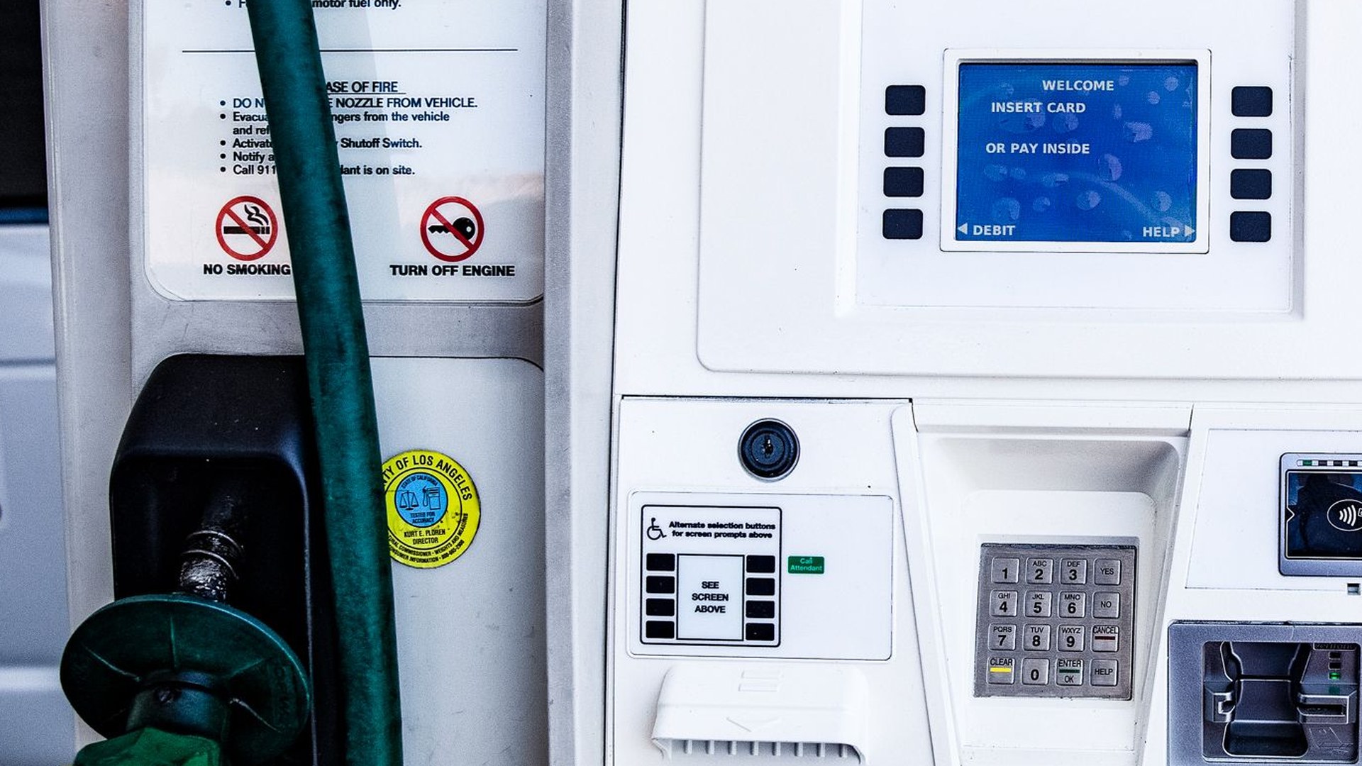 Panel de pago de una bomba de gasolina con ranura de tarjeta y teclado numérico en primer plano, marcas recortadas