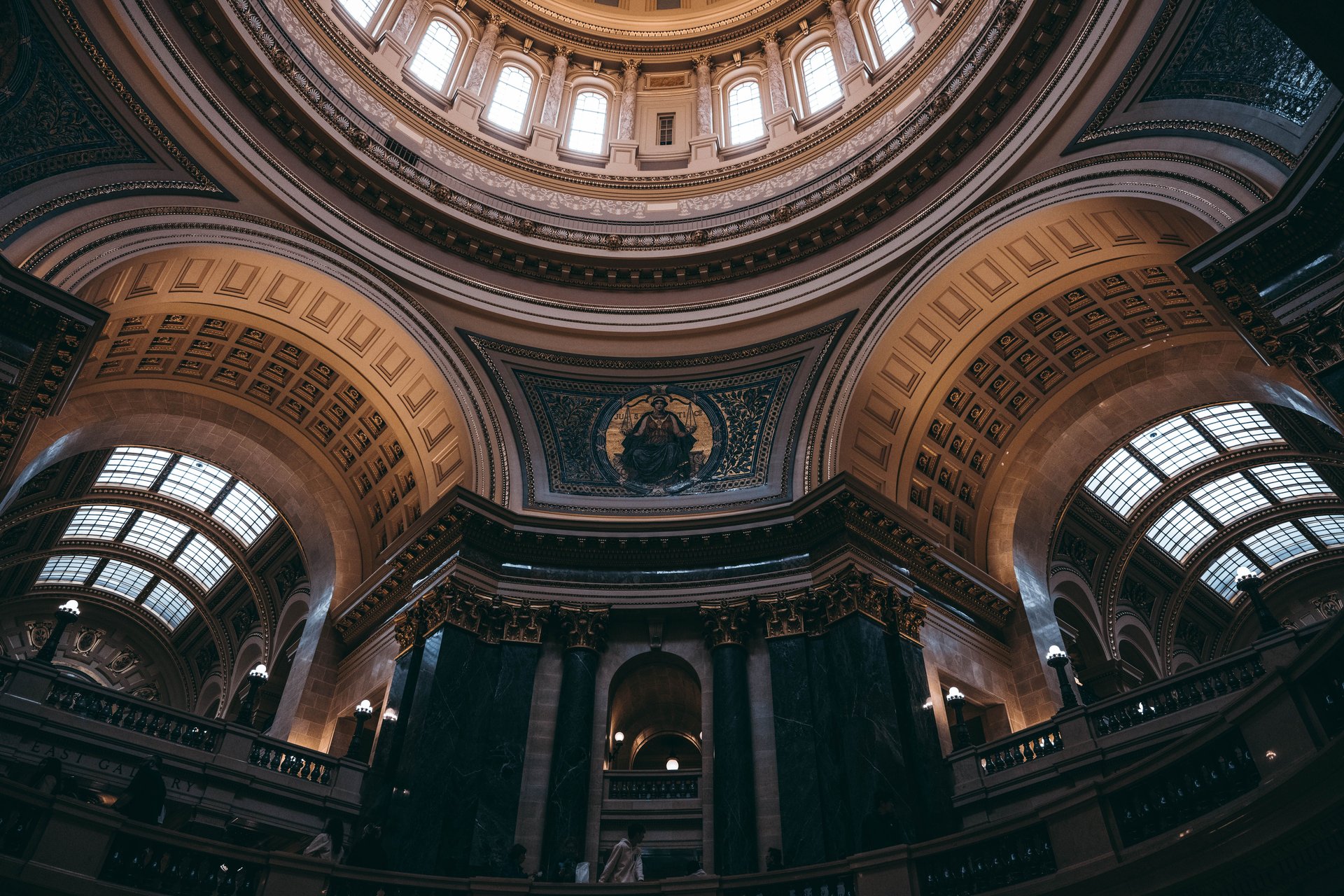 Cúpula interior de edificio legislativo neoclásico con columnas, artesonado, mosaico central y luz cálida, sin texto visible, sin logos de vendors.