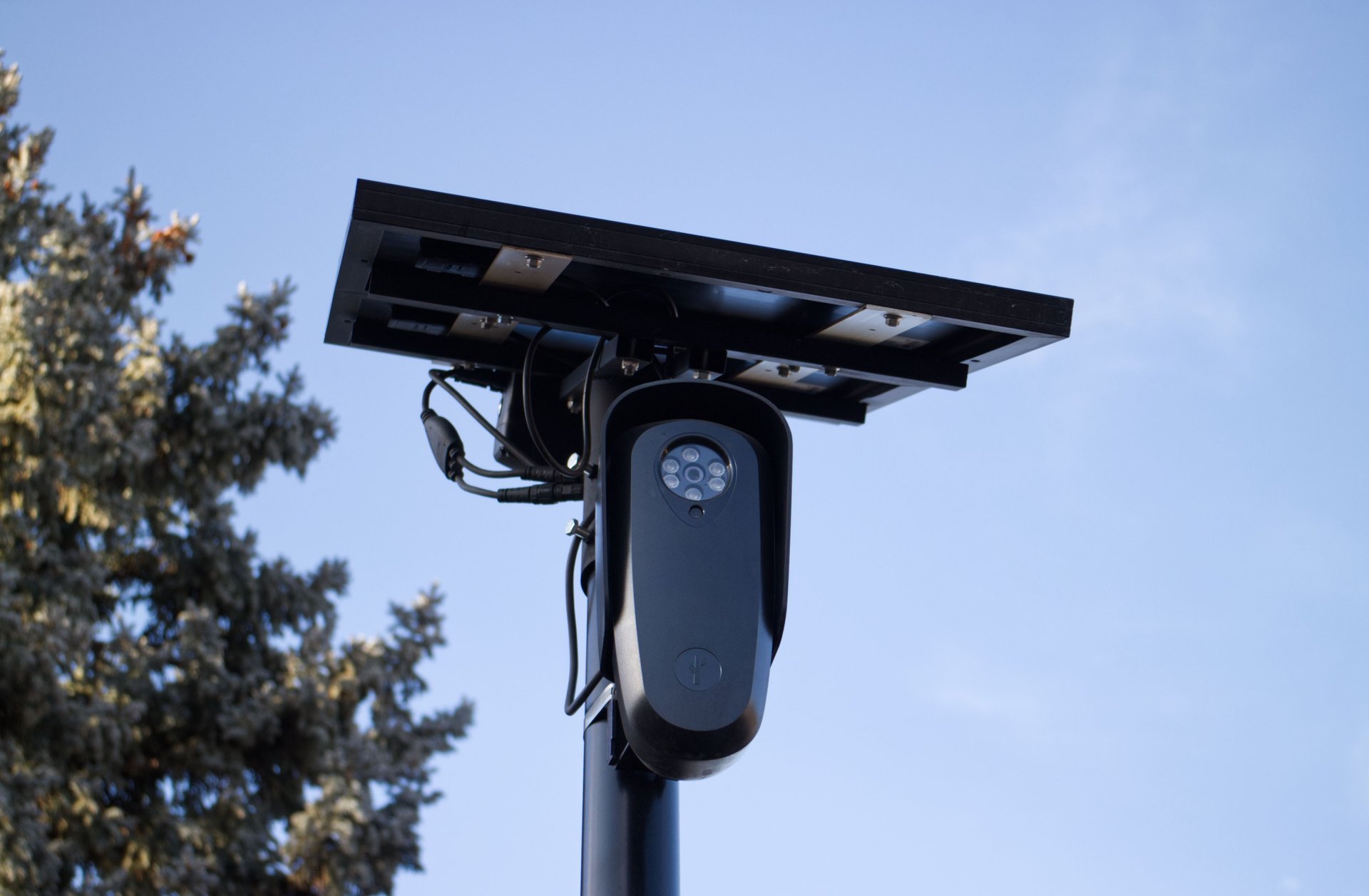 Cámaras de vigilancia tipo ALPR montadas en poste con módulo solar y antena de comunicaciones en entorno suburbano